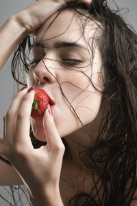 Woman eating strawberry.
